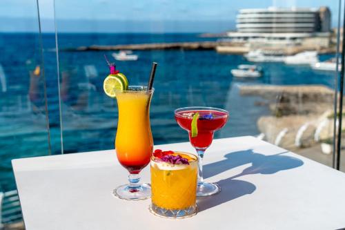 two drinks on a table with a view of the water at Labranda Riviera Hotel & Spa in Mellieħa