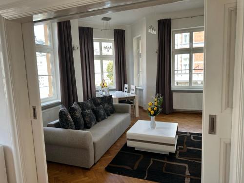 - un salon avec un canapé et une table dans l'établissement Villa Wingolf, à Karlovy Vary