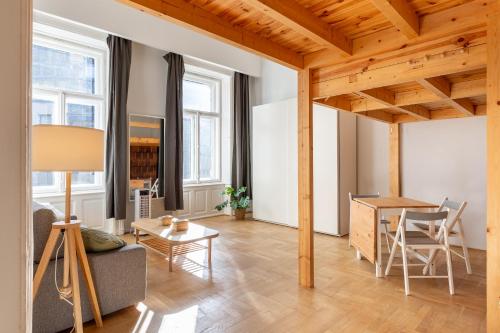 sala de estar con techo de madera y mesa en V26 Freedom Lodge Apartment, en Budapest
