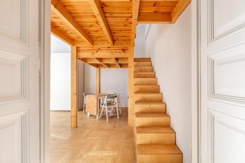 a staircase in a room with white walls and wooden ceilings at V26 Freedom Lodge Apartment in Budapest