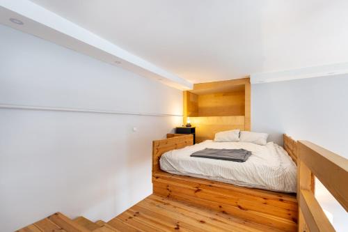 a bedroom with a bed with white walls and wooden floors at V26 Freedom Lodge Apartment in Budapest