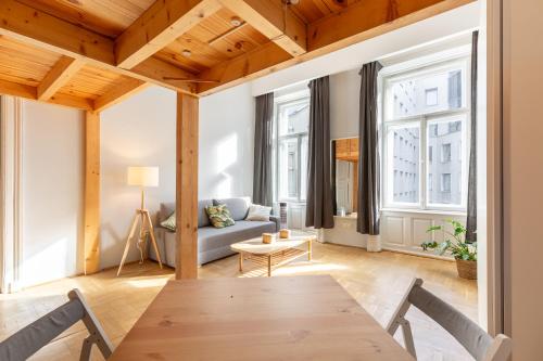 uma sala de estar com uma mesa e um sofá em V26 Freedom Lodge Apartment em Budapeste