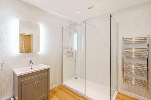 a bathroom with a shower and a sink at Peregrine Cottage with Hot Tub in Newton Stewart