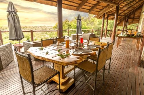 a wooden table and chairs on a deck at Elephant Rock Private Safari Lodge in Ladysmith
