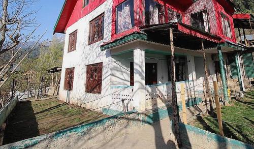 ein altes Haus mit Rot und Weiß in der Unterkunft OYO Flagship 4945 AR LODGE in Srinagar