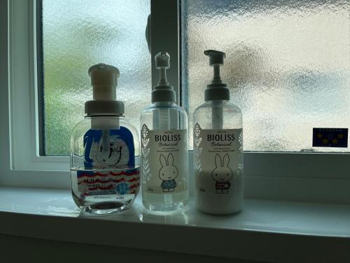 zwei Flaschen auf einem Fensterbrett neben in der Unterkunft 赤だすき_別邸 in Hakuba