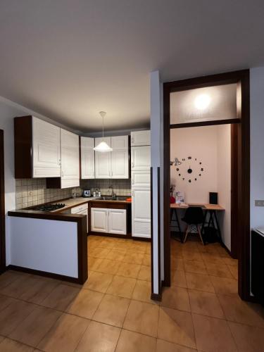 cocina con armarios blancos y mesa en Appartamento Ai Palasi, en Vittorio Veneto