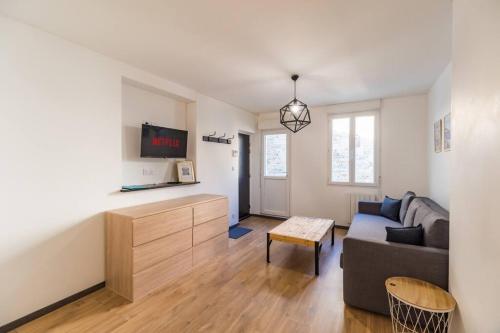 un salon avec un canapé et une télévision dans l'établissement L'escale en plein coeur de Lannion, à Lannion