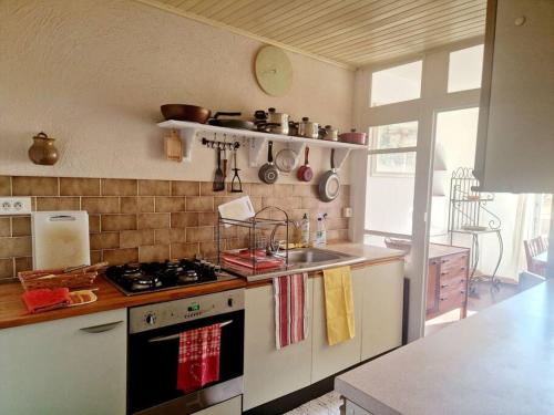 a kitchen with a stove and a sink at petite maison de village calme in Rodès