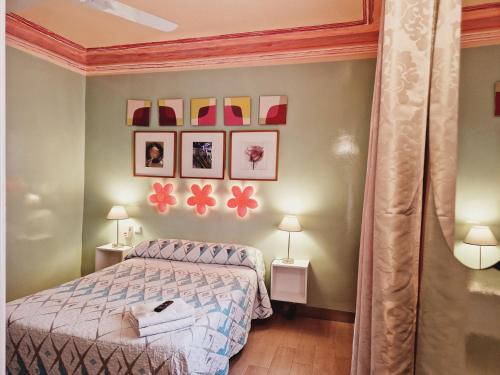 馬德里的住宿－多爾斯維塔旅館，一间卧室配有一张床,墙上挂着一些图片