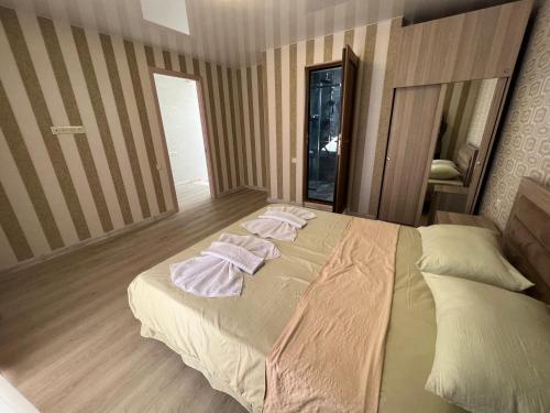 a bedroom with a large bed with towels on it at Villa for families and friends 4 in Tbilisi City
