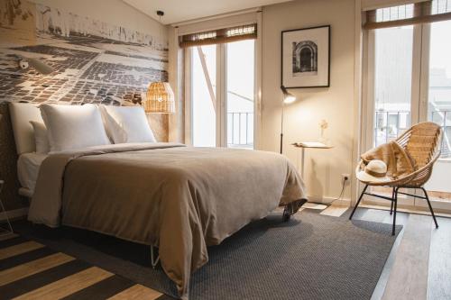 1 dormitorio con 1 cama grande y 1 silla en room Select Liberdade en Lisboa