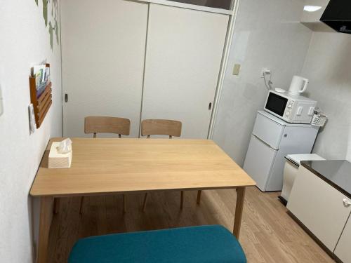 une petite cuisine avec une table et un four micro-ondes dans l'établissement happy house302 -駐車場無料, à Shimminatomachi