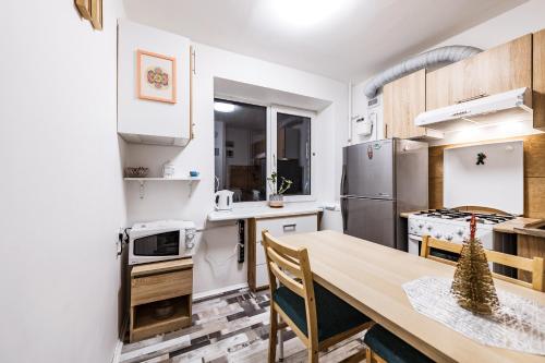 Il comprend une cuisine équipée d'une table et d'un réfrigérateur. dans l'établissement Cozy Apartment in Kaunas with Free Parking, à Kaunas