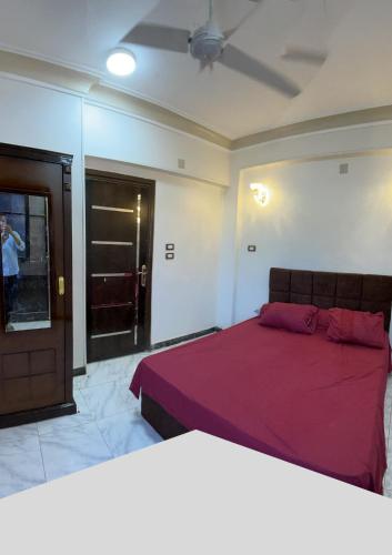a bedroom with a large bed with a red blanket at Tabia Tower City center aswan in Aswan