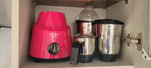 a pink blender and other appliances sitting on a shelf at Castle HSR Sarjapur Road in Bengaluru