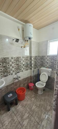 een badkamer met 2 toiletten en een wastafel bij Castle HSR Sarjapur Road in Bangalore