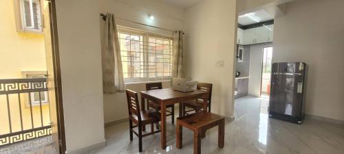 a kitchen with a table and chairs and a refrigerator at Castle HSR Sarjapur Road in Bengaluru