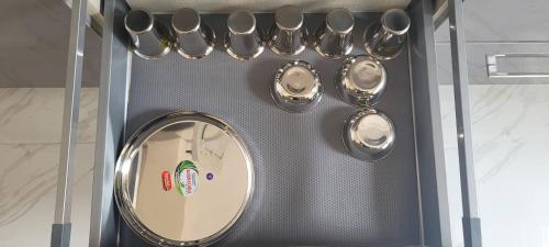 a wall with a mirror and some silver utensils at Castle HSR Sarjapur Road in Bengaluru