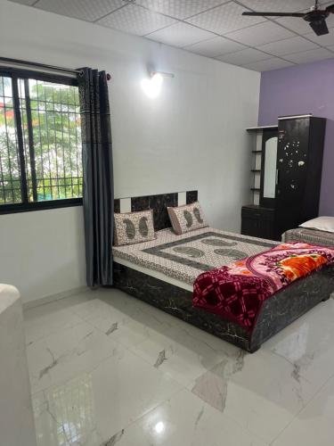 a bedroom with a bed in a room with a window at Apna Farmhouse - Private Villa with Pool & Play area - Near Fort -15 min to Ellora Caves in Daulatābād