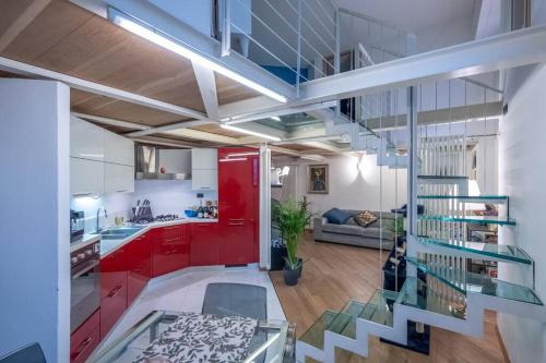 una cucina e un soggiorno con armadi rossi e scala di PVR Guest House a Milano