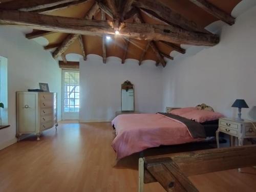 a bedroom with a large bed and a wooden floor at Cottage chaleureux au calme 