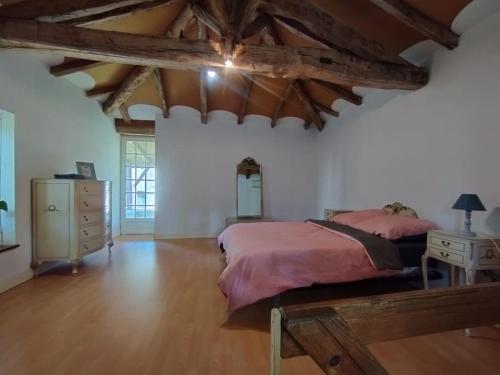 ein Schlafzimmer mit großem Bett und Holzboden in der Unterkunft Cottage chaleureux au calme in Salles-de-Barbezieux