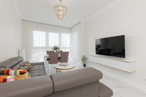 ワルシャワにあるBusiness Apartments Kasprzaka by Noclegi Rentersのソファとテレビのあるリビングルーム