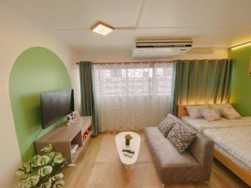 a living room with a bed and a couch at PTJ Style Condotel คอนโดเมืองทอง P2 in Nonthaburi