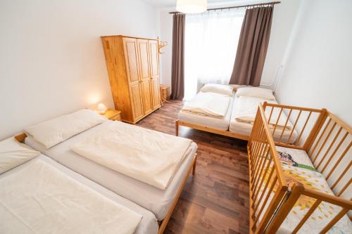 ein kleines Zimmer mit 2 Betten und einem Fenster in der Unterkunft Apartmány Olešnice in Olešnice v Orlických horách