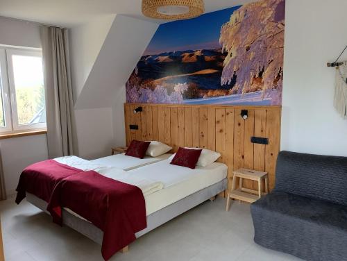 een slaapkamer met een bed met een schilderij aan de muur bij Pod Wielką Zalesioną Górą in Wetlina