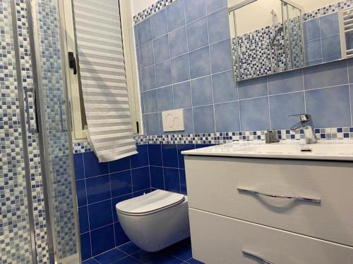 Baño de azulejos azules con aseo y lavamanos en Vista Mare, en Pescara