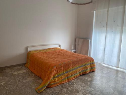 1 dormitorio con 1 cama con manta naranja en Vista Mare, en Pescara