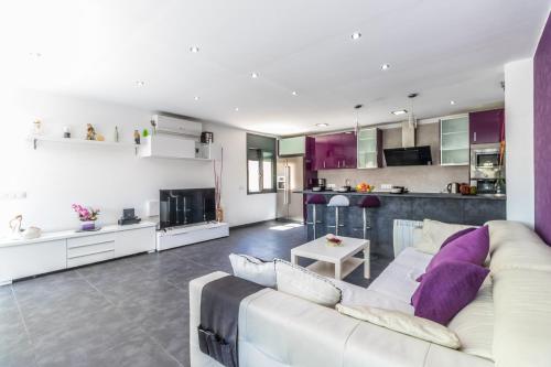 a living room with a white couch and a kitchen at Villa de lujo. Piscina con jacuzzi. in Empuriabrava