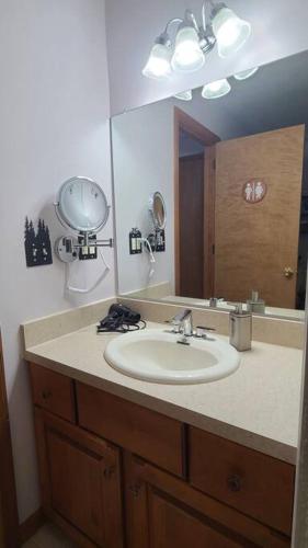 a bathroom with a sink and a large mirror at Luxury getaway in woods, Jacuzzi, Hot Tub, Pool in Bushkill