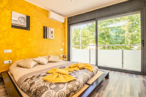 a bedroom with a bed with yellow walls and a large window at Villa de lujo. Piscina con jacuzzi. in Empuriabrava