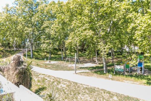 a path through a park with trees and a playground at Villa de lujo. Piscina con jacuzzi. in Empuriabrava