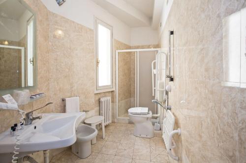 a bathroom with a sink and a toilet and a shower at Hotel Minerva in Siena