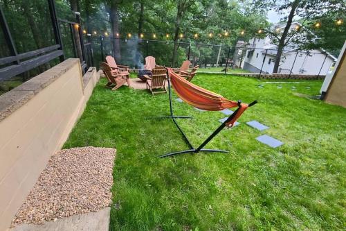 a hammock sitting on the grass in a backyard at Luxury getaway in woods, Jacuzzi, Hot Tub, Pool in Bushkill