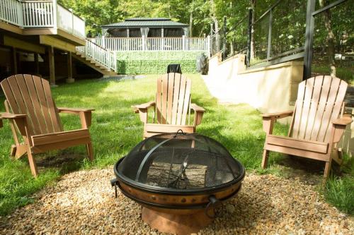 two chairs and a fire pit in a yard at Luxury getaway in woods, Jacuzzi, Hot Tub, Pool in Bushkill