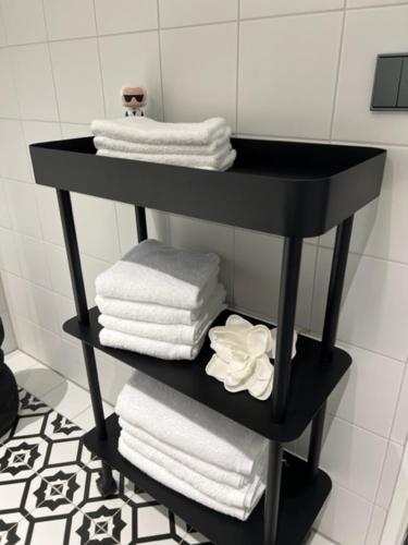 a black shelf with towels on it in a bathroom at InkBlue-Apartment in Heidenau