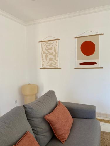 a living room with a couch and some pictures on the wall at Beach house upscale villa with pool in Costa da Caparica