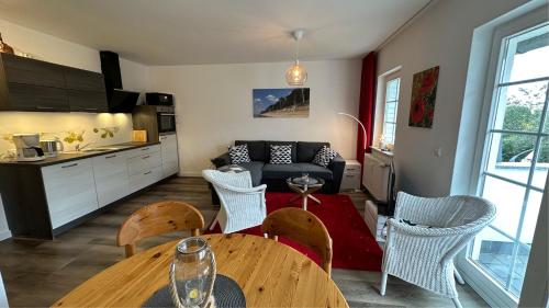 a kitchen and a living room with a table and chairs at Gemütliche FeWo mit Balkon nahe der Ostsee - 2 Schlafzimmer in Wischuer