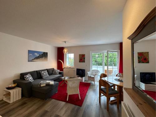 a living room with a couch and a table at Gemütliche FeWo mit Balkon nahe der Ostsee - 2 Schlafzimmer in Wischuer