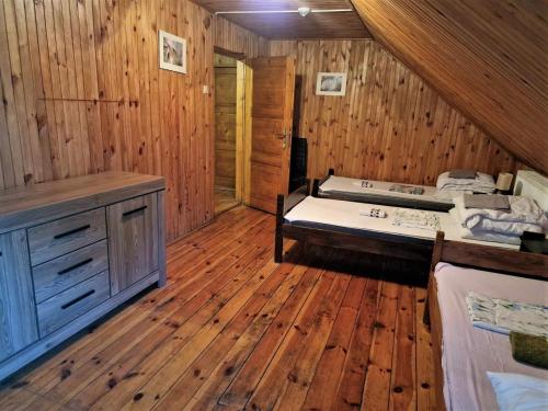 a bedroom with a bed in a wooden room at Hostel Domek Ogrodnika przy Muzeum w Przeworsku Zespole Pałacowo - Parkowym in Przeworsk