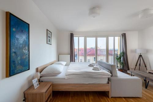 um quarto com uma cama grande e uma janela grande em Sunny Safron apartment em Praga