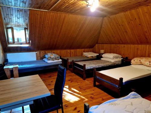 pokój z 3 łóżkami i stołami w kabinie w obiekcie Hostel Domek Ogrodnika przy Muzeum w Przeworsku Zespole Pałacowo - Parkowym w mieście Przeworsk