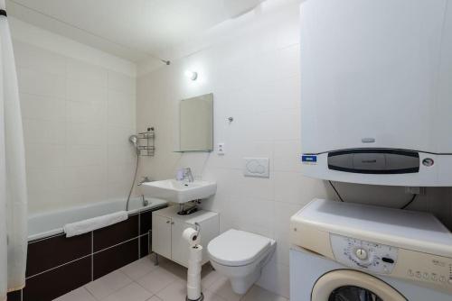 uma casa de banho branca com um lavatório e um WC em Sunny Safron apartment em Praga