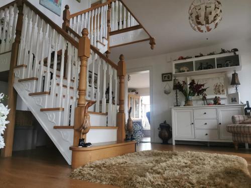 a living room with a staircase with a rug at Cherrytree House B&B in Moville