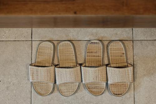 a row of four rattan shoes sitting on the ground at Moringa Ubud Villa in Ubud